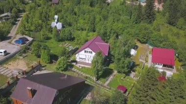 Güzel modern evleri ve yeşil ağaçları olan kırsal köy manzarası. Şarjör. İkamet yerlerinin parlak renkli çatılarının en üst manzarası.