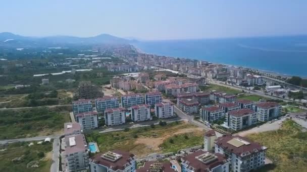 Vista aérea de la ciudad costera en Grecia. Art. Muchos edificios y casas construidas en la zona montañosa frente al azul hermoso mar en un día soleado de verano . — Vídeo de stock