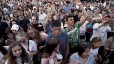 Macaristan, Budapeşte - 09.15.2019: Birçok insan bir müzik festivalinde şarkı söyleyip dans ediyor. Başla. Seyirciler açık hava konserinin tadını çıkarıyor ve eğleniyorlar..