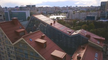 Kırmızı kiremitli çatısı olan güzel bir apartmanın havadan aşağı manzarası. - Sanat. Şehirde yeşil parkı olan modern bir ev. Mimarlık konsepti..