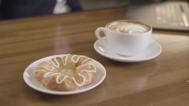 Bir fincan sıcak kahve ve ahşap masada jöleli tatlı çörek. Stok görüntüleri. Ev yapımı çörek ve kapuçino 'nun mükemmel kahvaltısına yakın..