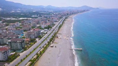 Şehrin deniz kıyısı ve kumlu sahili boyunca uzanan muhteşem manzarası. - Sanat. Şehir merkezi kıyı şeridinin hava manzaralı seti ve sürüş arabaları ile yol manzarası..