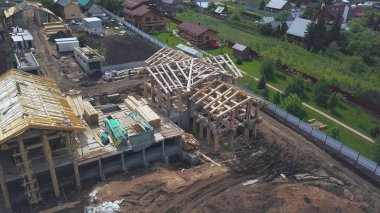 Kırsal bölgenin yukarısından yeni ahşap bina. Şarjör. Yeşil yaz köyünün havadan görünüşü ve yeni ahşap bir ev..