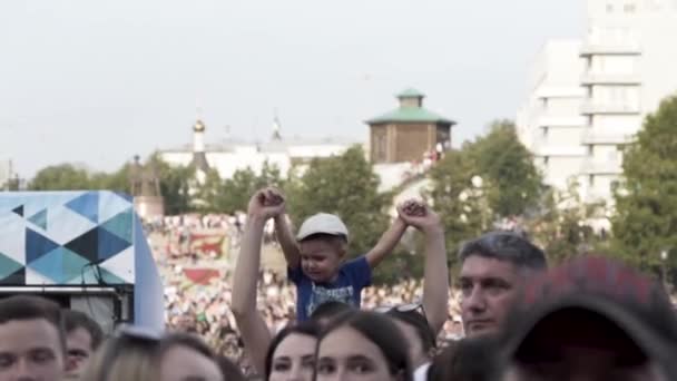 Alemania - Berlín, 09.13.2019: llorando infeliz niño sentado sobre los hombros de su papá entre los fanáticos de la música animadora. Acción. Multitud en el evento musical en la calle de la ciudad . — Vídeos de Stock