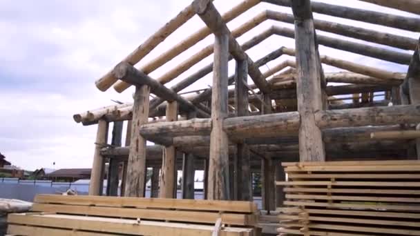 New house made of wooden beams at the construction site, carpentry concept. Clip. Unfinished ecologically friendly residential house. — 图库视频影像