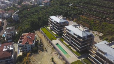 Dağlık bölgedeki küçük otelin havadan görünüşü, tatil ve yaz tatili konsepti. - Sanat. Yüzme havuzlu otel, tarım arazileriyle çevrili..