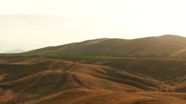 Vue aérienne d'excitantes collines rouges couvertes d'arbustes et de grandes fermes vertes contre le ciel du soir en été. Paysages étonnants et colorés — Video