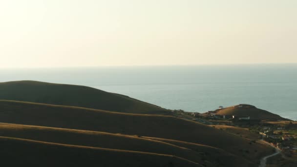 Vue aérienne de hautes collines verdoyantes et de la mer bleue sur fond de ciel nocturne en été. Paysages étonnants et colorés — Video