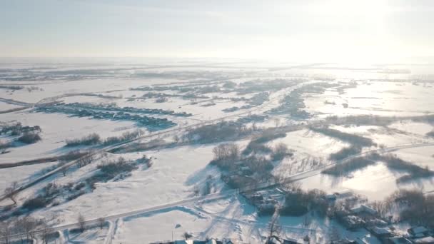 Aerial view of the typical Russian village covered with snow and countryside road. Shot. Winter in Russia, the periphery of Russia — Stockvideo