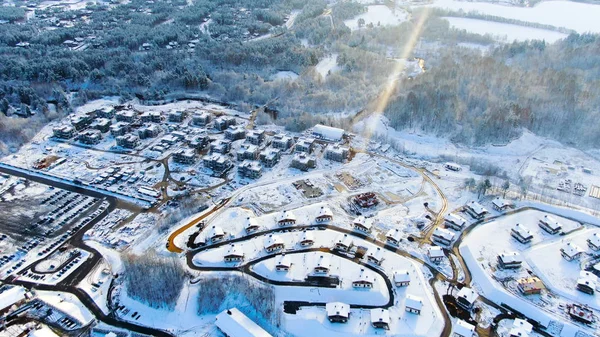 Río fluye cerca de pequeño pueblo en invierno, paisaje aéreo, concepto de clima frío. Viaje. Impresionante vista de la zona rural fría cerca del bosque de coníferas . — Foto de Stock