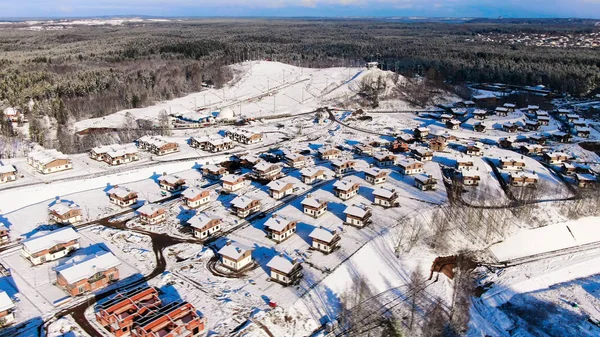 Aerial view of winter village near the pine tree forest. Journey. Amazing flight above houses and cottages covered by snow located in ecological area. — Stock Photo, Image