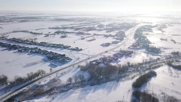 Aerial view of the typical Russian village covered with snow and countryside road. Shot. Winter in Russia, the periphery of Russia — Stockvideo