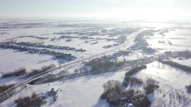 Aerial view of the typical Russian village covered with snow and countryside road. Shot. Winter in Russia, the periphery of Russia