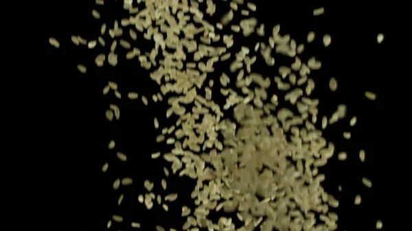 Detailní záběr bílých sezamových semen letících vzhůru izolovaných na černém pozadí, jídlo a koncepce přípravy. Záběry ze skladu. Mnoho sezamových semen, asijská kuchyně. — Stock fotografie
