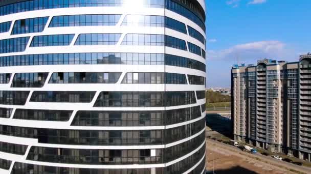 Kontorsbyggnad med glasfasad på blå molnig himmel bakgrund. Resan. Flygfoto av modernt kontorshotell nära bostadsområde. — Stockvideo