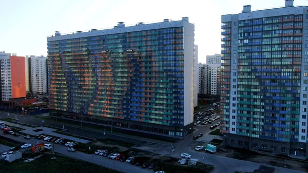 Luchtfoto van residentiële wijk met hoge gebouwen met ongewone kleurrijke gevels op een heldere hemel achtergrond. Reis. Avondzon en de nieuwe appartementenhuizen. — Stockfoto