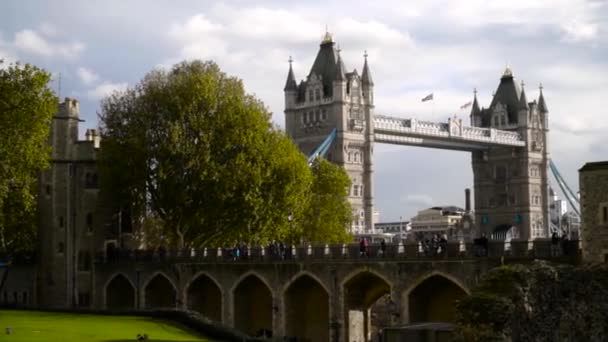 Hermosa vista de la arquitectura antigua de fortaleza y puente con torres. Acción. Turistas paseando por el casco antiguo con arquitectura medieval en paseo marítimo con puente y torres — Vídeo de stock