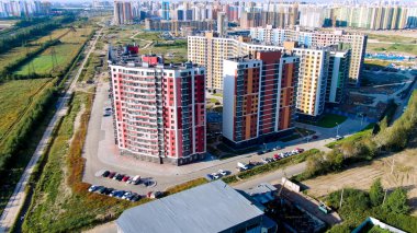 Yeşil çimlerle çevrili birçok yüksek binası olan yeni modern şehir bölgesinin havası. Hareket. Mimarlık konsepti, yazın güzel gökdelenler..