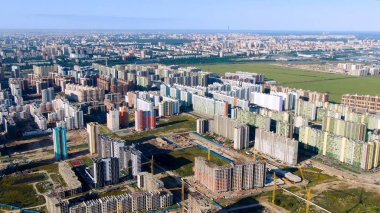 Yeşil çimlerle çevrili birçok yüksek binası olan yeni modern şehir bölgesinin havası. Hareket. Mimarlık konsepti, yazın güzel gökdelenler..