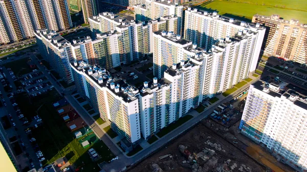 Hoge gebouwen met kleurrijke gacades in nieuwe moderne stadswijk. Beweging. Vliegen in de buurt van ontwikkelingsgebied met nieuwe woningen. — Stockfoto