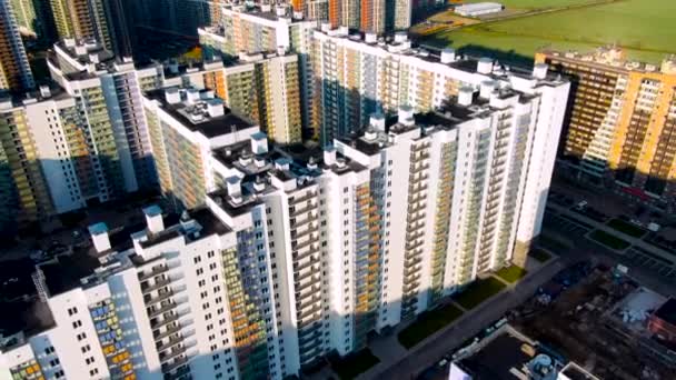 Novos edifícios residenciais modernos com fachadas coloridas em nova área da cidade, expansão do conceito de subúrbios. Moção. Vista aérea de novas casas altas, infra-estrutura e desenvolvimento . — Vídeo de Stock