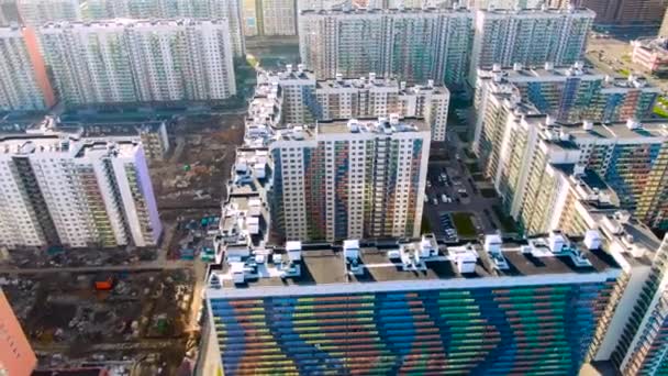Moderne nieuwe woongebouwen met kleurrijke gevels in een nieuw deel van de stad, uitbreiding van de voorsteden concept. Beweging. Luchtfoto van hoge nieuwe huizen, infrastructuur en ontwikkeling. — Stockvideo
