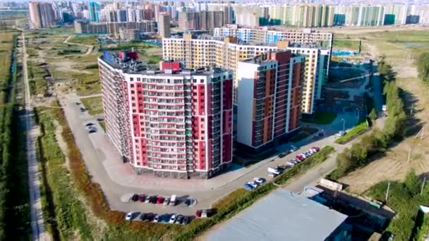 Aérea del nuevo distrito moderno de la ciudad con muchos edificios de gran altura rodeados de césped verde. Moción. Concepto de arquitectura, hermosos rascacielos en verano . — Vídeo de stock