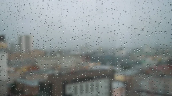 雨滴在有背景的玻璃杯上. 库存录像。 *雨点落在城市的背景* — 图库照片