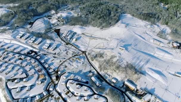 Aerea del paesaggio invernale, piccola città nel nord della Russia con alberi ricoperti di neve dopo pesanti nevicate. Mozione. Volare sopra gli alberi di pino foresta e piccole case . — Video Stock