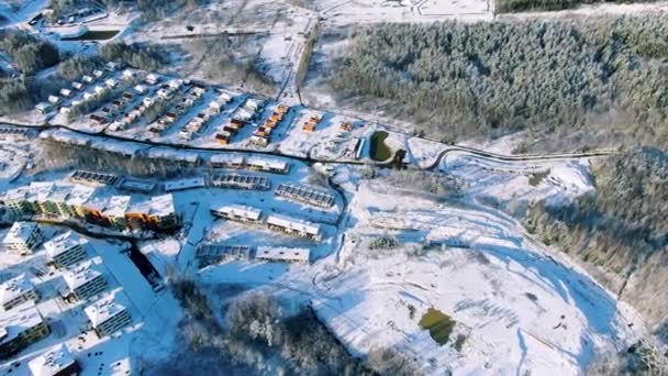 Vista de invierno del asentamiento rural suburbano ruso con árboles verdes cubiertos de nieve y un pequeño lago verde congelado. Moción. Aérea de paisaje invernal impresionante . — Vídeo de stock