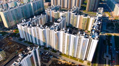 Yazın güneşli bir günde yeşil alana yakın yeni konut yüksek binaları olan inşaat alanı. Hareket. Şehrin modern bölgesinin havadan görünüşü.