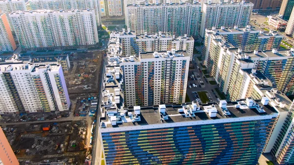 Vista aérea dos edifícios de vários andares, bloco de apartamentos, playgrounds dentro do quintal. Moção. Voando acima das novas casas coloridas e estradas com carros estacionados . — Fotografia de Stock