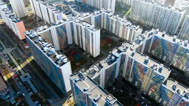 Top uitzicht op de stad straat met nieuw gebouwde woningen, onroerend goed concept. Beweging. Vogels oog boven uitzicht op witte gebouwen met kleurrijke balkons op een zomerdag. — Stockvideo