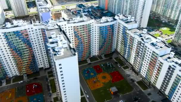 Moderno apartamento de rascacielos de cristal de color blanco con líneas curvas de colores en la fachada. Moción. Vista aérea de casas altas con instalaciones exteriores y exteriores . — Vídeo de stock