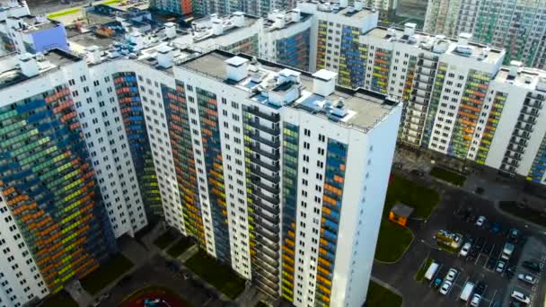 Flying over the residential houses with bright colorful facadesin a summertime. Motion. Aerial of the white buildings and inner yard with parked cars. — Stock Video