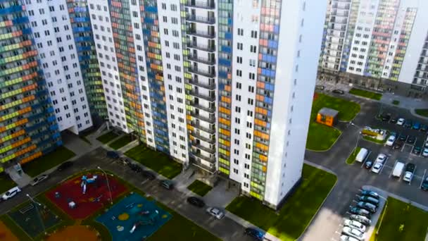 Antenne für den Bau von Mehrfamilienhäusern im Schlafbereich der Großstadt. Bewegung. Wohnhochhaus mit blauen, orangen, grünen und gelben Glasbalkonen. — Stockvideo