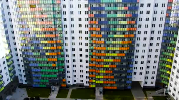 Grandi condomini colorati in insediamento residenziale con prato verde vicino alle porte d'ingresso. Mozione. Bellissimi grattacieli nella moderna area della città . — Video Stock