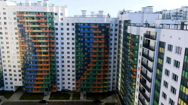 Moderno apartamento de rascacielos de cristal de color blanco con líneas curvas de colores en la fachada. Moción. Vista aérea de casas altas con instalaciones exteriores y exteriores . — Foto de Stock