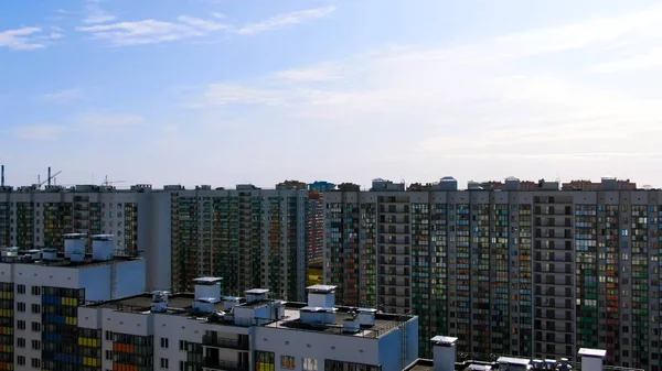 Righe bianche di case a più piani con facciate colorate a strisce contro il cielo blu con nuvole. Mozione. Vista aerea di condomini residenziali . — Foto Stock
