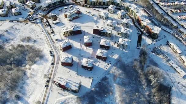 Top uitzicht op de stad in de winter met sneeuw op de daken op een zonnige dag. Beweging. Mooie zonnige dag in de stad in de winter — Stockvideo