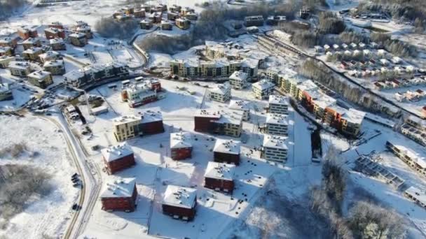 Top uitzicht op de stad in de winter met sneeuw op de daken op een zonnige dag. Beweging. Mooie zonnige dag in de stad in de winter — Stockvideo