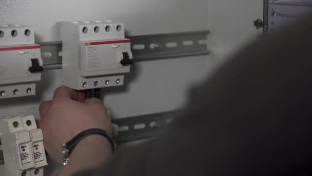 Närbild av elektrisk växel med automater och ledningar. Lagerbilder. Manliga händer som utför installation av elektrisk sköld. — Stockvideo