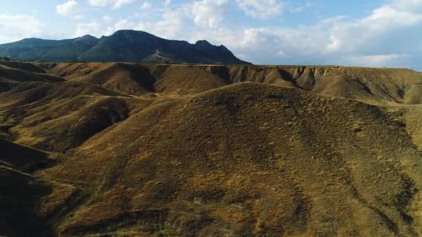 Panoramic view of Black Sea coastline mountains and yellow hills on a sunny autumn day, hiking and nature concept. Shot. Aerial of yellow dried cliff shore on blue cloudy sky background. — Stock Video