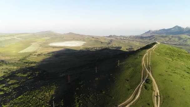 Montanhas verdes cobriram grama verde no fundo do céu azul. Atingido. Vista superior de colinas verdes em um dia ensolarado — Vídeo de Stock