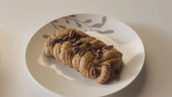 Close up de croissant recém-assado e pães doces deitado em placas de cerâmica em uma fileira no fundo da mesa branca. Imagens de stock. Conceito de produtos de padaria e alimentos . — Fotografia de Stock