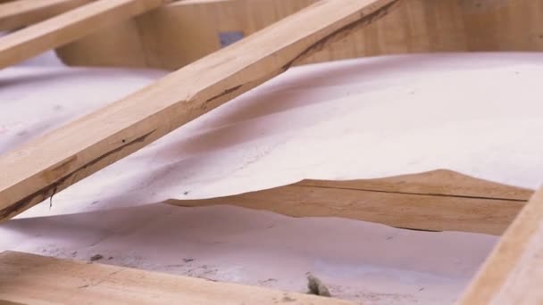 Close up de telhado de madeira inacabado de uma nova casa no local de construção com pano de proteção branco acenando ao vento, conceito de carpintaria. Clipe. Partes de novo edifício ecológico . — Vídeo de Stock