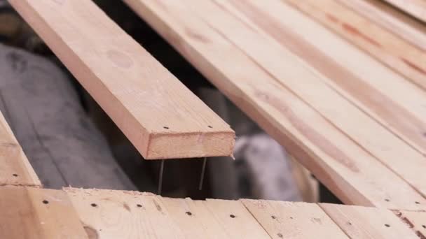Construction of a house made of timber. Clip. Close up of wooden board on the roof of unfinished ecological house, carpentry concept. — Stock Video