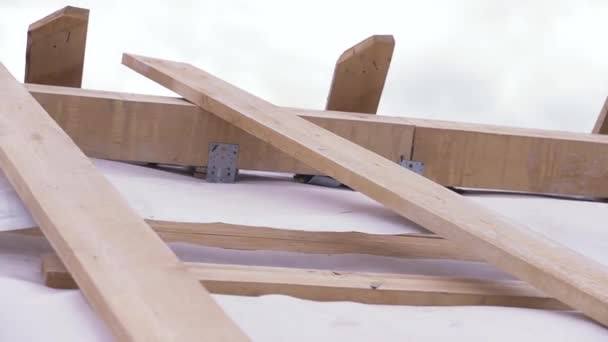 Primer plano del techo de madera sin terminar de una casa nueva en el sitio de construcción con tela protectora blanca ondeando en el viento, concepto de carpintería. Clip. Partes del nuevo edificio ecológico . — Vídeo de stock