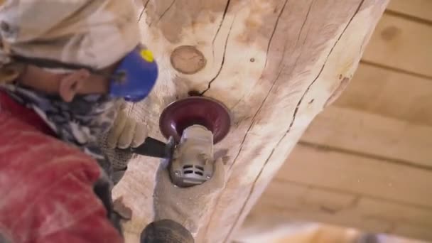 El carpintero pule manualmente la viga con una amoladora eléctrica de madera en el sitio de construcción. Clip. Trabajador masculino limpiando madera de hongos y moho . — Vídeo de stock