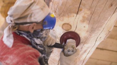 Yeni evin şantiyesindeki çam kütüklerinin cilalama makinesi tarafından öğütülüyor. Şarjör. İnşaat alanında mantar ve küften odun temizliyorum..
